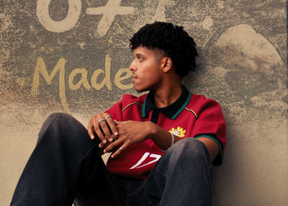 Wearing the Section 90 Portugal No. 17 knitted jersey with jeans, sitting against a painted wall